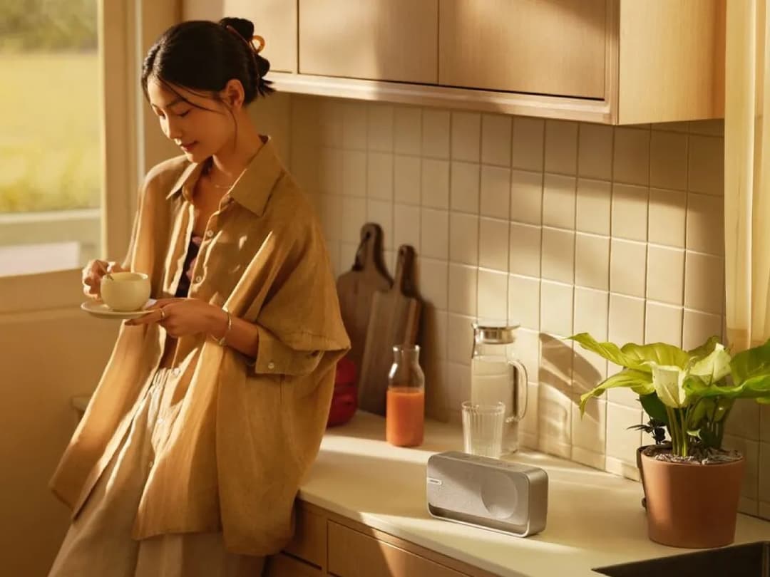 Woman having coffee in her kitchen listening to Bose SoundLink Home